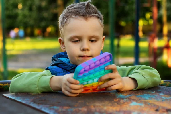 Stylish Boy Hold His Hands Sensory Toy Pop Play Rainbow — Stock Photo, Image