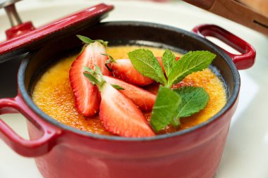 Taze nane ve çilekle süslenmiş tatlı kremalı brulee 'nin en üst manzarası..