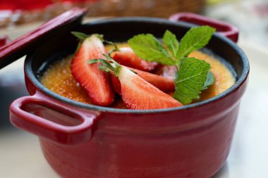 Taze nane ve çilekle süslenmiş tatlı kreması brulee 'nin yakın çekimleri..