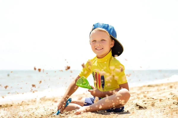 Όμορφο Χαμογελαστό Αγόρι Που Κάθεται Στην Παραλία Και Παίζει Την — Φωτογραφία Αρχείου