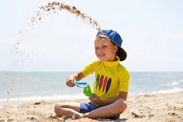 Mooie Lachende Jongen Die Het Strand Zit Met Zand Speelt — Stockfoto