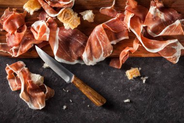 Esmer arka planda Prosciutto dilimleri. Üst görünüm.