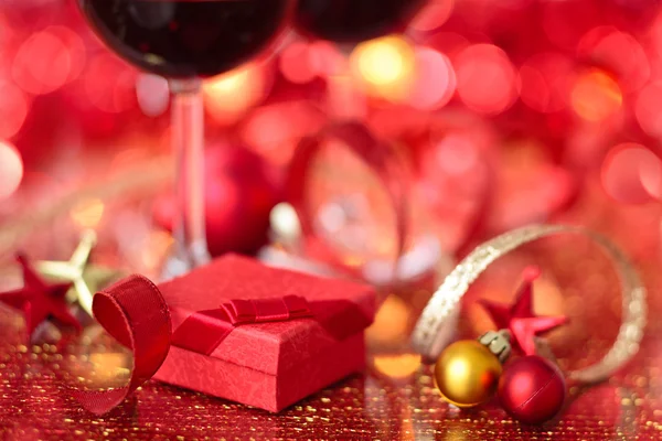 Regalo y vino para vacaciones contra las luces borrosas . — Foto de Stock