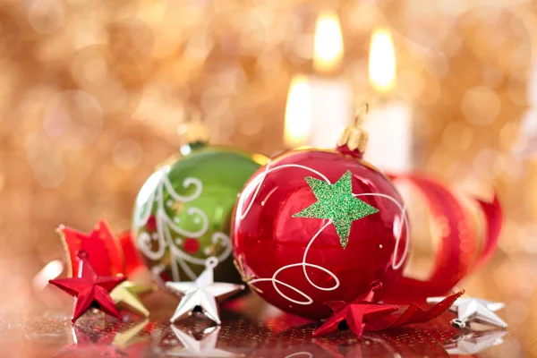 Christmas balls with stars and candles against holiday lights. — Stock Photo, Image