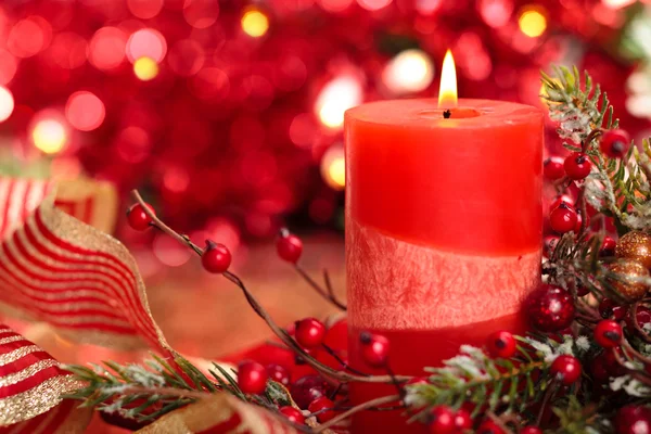 Christmas decoration with candle against red holiday lights. Stock Image