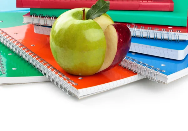 Школьные принадлежности и зеленое яблоко на переднем плане . — стоковое фото