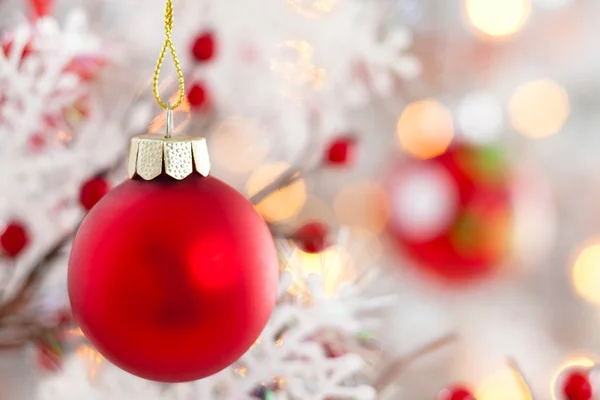 Röda bollen med snöflinga som hänger på trädet. — Stockfoto