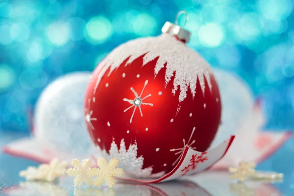 Bola de Navidad con copo de nieve y estrellas contra luces navideñas . — Foto de Stock