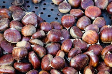 Sonbahar ve kış kırsal tatlıları büyük bir metal kasede kavrulmuş kestaneler, bir sokak yemeği festivalinde satışta, mevsimsel yemek fotoğraflarında seçici bir odak noktası var.