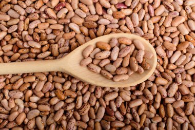 Yumuşak odaklanarak çekilmiş organik vejetaryen yiyeceklerin üst ya da üst görüntüsü, taze organik kırmızı fasulyelerde bir tahta kaşığın üst görüntüsü.