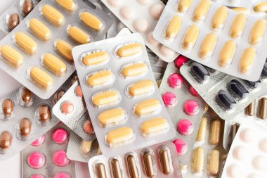 Beyaz arka planda izole edilmiş farklı ilaç hapları, haplar ve vitaminler, yumuşak odaklı eczacılık fotoğrafı