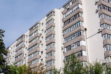Romanya 'nın Bükreş kentinde açık mavi gökyüzüne doğru yenilenmiş tipik eski apartman blokları