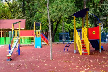 Romanya 'nın Bükreş kentinde güneşli bir yaz gününde karışık plastik ve metalik oyuncaklar ve malzemelerle dolu renkli çocuk parkı