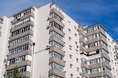 Romanya 'nın Bükreş kentinde açık mavi gökyüzüne doğru yenilenmiş tipik eski apartman blokları