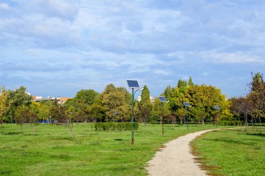 Romanya 'nın Bükreş kentindeki Parcul Izvor (Izvor Park) kentindeki mavi güneş panelleriyle birlikte uzun bir ara sokak ve çok sayıda aydınlatma direği etkinleştirildi.