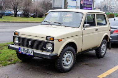 Bükreş, Romanya, 4 Ocak 2021 Rusya 'dan gelen beyaz Lada Niva arabası güneşli bir kış gününde bir sokağa park etti