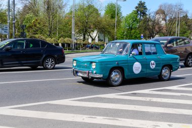 Bükreş, Romanya, 24 Nisan 2021 Güneşli bir bahar gününde sokakta trafikte eski ve canlı mavi turkuaz Rumen Dacia 1100 klasik otomobili