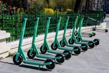 Bükreş, Romanya, 10 Nisan 2021: Şehir merkezinde vatandaşlar ve turistler için özel mobil uygulama kullanılarak kiralık elektrikli scooterlar