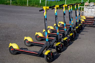 Bükreş, Romanya, 24 Nisan 2021: Şehir merkezinde vatandaşlar ve turistler için uygun olan özel mobil uygulama kullanılarak kiralık elektrikli scooter 'ların suya düşmesi