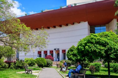 Bükreş, Romanya - 6 Mayıs 2021: Güneşli bir bahar gününde şehir merkezinde bulunan Üniversite Meydanı (Piata Universitatii) yakınlarındaki Ulusal Tiyatro (Teatrul National)