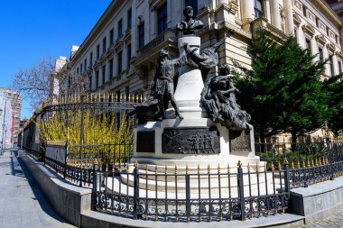 Bükreş, Romanya - 27 Mart 2021: Güneşli bir bahar gününde şehir merkezindeki tarihi bir binada Romanya Merkez Bankası 'nın (Banca Nationala a Romaniei, BNR) önündeki heykel