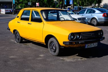 Bükreş, Romanya - 5 Haziran 2021: Eski, canlı, turuncu Rumen Dacia 1300 klasik araba güneşli bir yaz gününde caddeye park etti