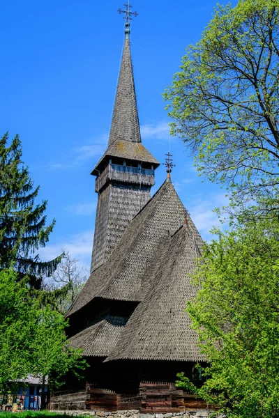 ルーマニア ブカレスト 2021年4月25日 春の晴れた日にヘラストラウ公園のディミトリ グスティ国立村博物館には 古いルーマニアの伝統的な教会が多くの古い木や緑の草で囲まれています — ストック写真