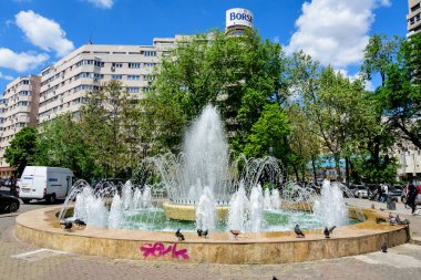 Bükreş, Romanya - 6 Mayıs 2021: Güneşli bir bahar gününde Üniversite Meydanı (Piata Universitatii) yakınlarında dekoratif su çeşmesi