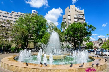 Bükreş, Romanya - 6 Mayıs 2021: Güneşli bir bahar gününde Üniversite Meydanı (Piata Universitatii) yakınlarında dekoratif su çeşmesi