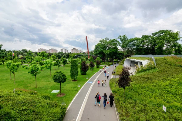 Bükreş, Romanya - 29 Mayıs 2021: Bulutlu bir yaz gününde, Drumul Taberei Parkı 'ndaki (Parcul Drumul Taberei) ara sokak ve canlı yeşil ağaçlarla çevrili manzara