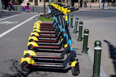Bükreş, Romanya, 10 Nisan 2021: Şehir merkezinde vatandaşlar ve turistler için uygun olan özel mobil uygulama kullanılarak kiralık elektrikli scooter 'ların suya düşmesi