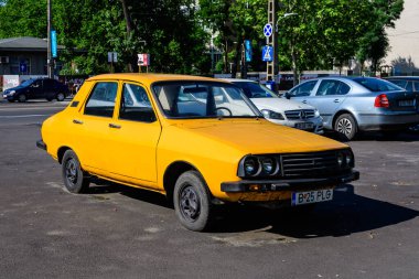 Bükreş, Romanya - 5 Haziran 2021: Eski, canlı, turuncu Rumen Dacia 1300 klasik araba güneşli bir yaz gününde caddeye park etti