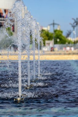 Şehir merkezindeki dekoratif bir fıskiyeye birçok su damlası ve su sıçraması seçici bir odak ile fotoğraflandı.