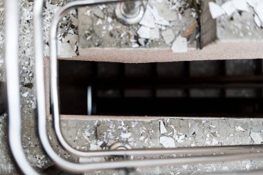 Terk edilmiş bir binanın sarmal merdivenleri. Sarmal beton bir merdiven aşağı iniyor.