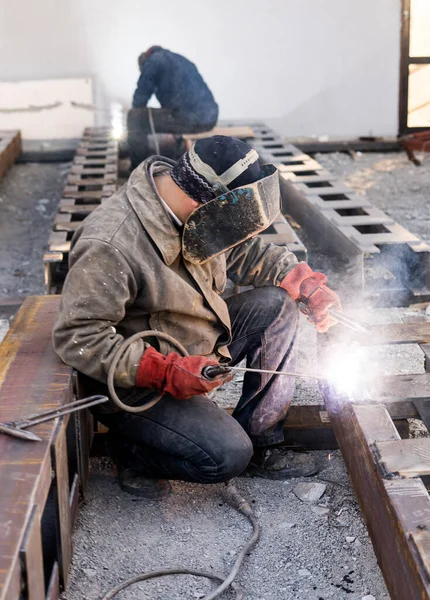 Kaynakçı elektrot ile yarı otomatik ark imalat üretim tesisinde çalışan