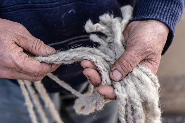 Geleneksel yün yapan yaşlı bir adamın elleri