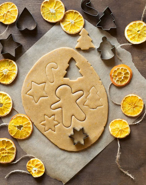 用面团做生姜饼干 用特殊的金属铸成的星星 圣诞树 小矮人的形状切碎饼干 干橙花环 顶部视图 — 图库照片