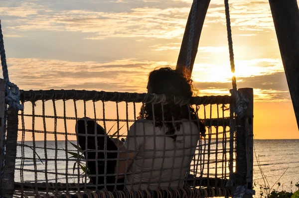 Vrouw zitten met zonsondergang achtergrond — Stockfoto