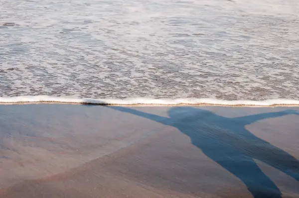 Stín mladá žena na pláži — Stock fotografie