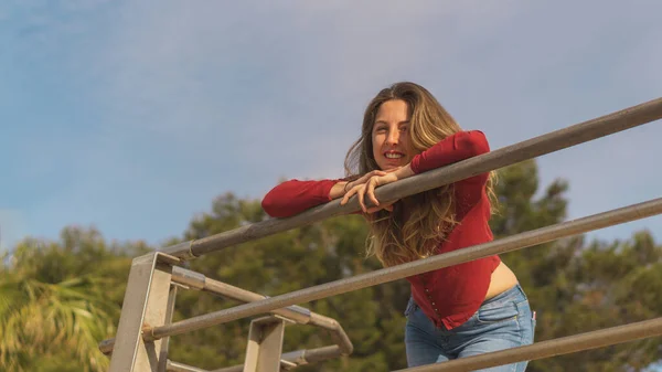 Attractive girl leaning on railing looking at camera — Foto de Stock