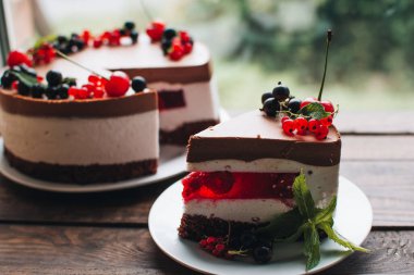 Ahşap bir masada dutlu kremalı pasta. Frenk üzümü ve kirazlı çikolatalı pasta. Doğum günü, düğün ve diğer tatiller için çilekli pasta..