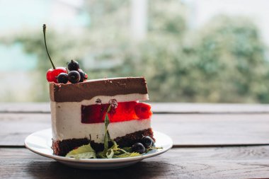 Ahşap bir masada dutlu kremalı pasta. Frenk üzümü ve kirazlı çikolatalı pasta. Doğum günü, düğün ve diğer tatiller için çilekli pasta..