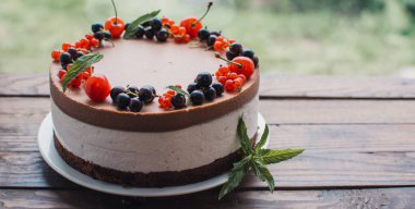 Ahşap bir masada dutlu kremalı pasta. Frenk üzümü ve kirazlı çikolatalı pasta. Doğum günü, düğün ve diğer tatiller için çilekli pasta..