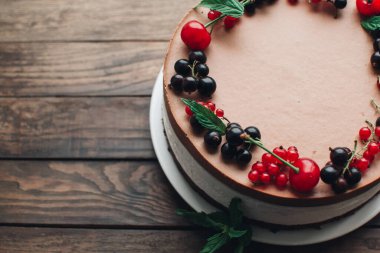 Ahşap bir masada dutlu kremalı pasta. Frenk üzümü ve kirazlı çikolatalı pasta. Doğum günü, düğün ve diğer tatiller için çilekli pasta..
