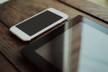 Ahşap arka planda bir telefon ve bir tablet. Telefon maketi. Ahşap arka planda akıllı telefon.