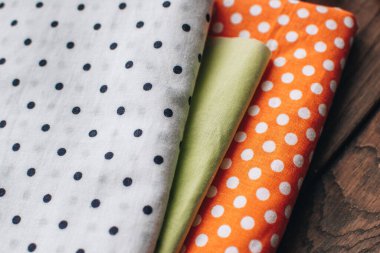 İğne işi konsepti. Çeşitli dikiş aletleri. İğneler, makas, düğmeler, makaralar, farklı renkte iplikler. Aksesuar ve kumaş dikiyorum. Dikiş iplikleri, iğneler, iğneler, ahşap bir arka planda kumaşlar.