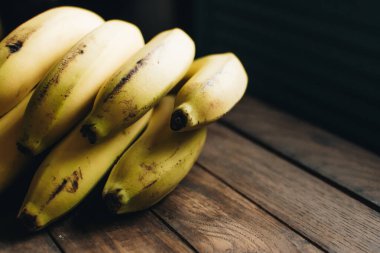 Ahşap arka planda tropik meyve. Meyve arka planı. Tahta bir masada muzlar.