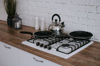 Yemek pişirme fırını. Çaydanlık ve kızartma tavası ocakta. Mutfak konsepti.