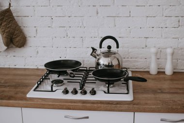 Yemek pişirme fırını. Çaydanlık ve kızartma tavası ocakta. Mutfak konsepti.