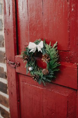 Tahta kırmızı kapıda Noel çelengi. Noel dekoru..